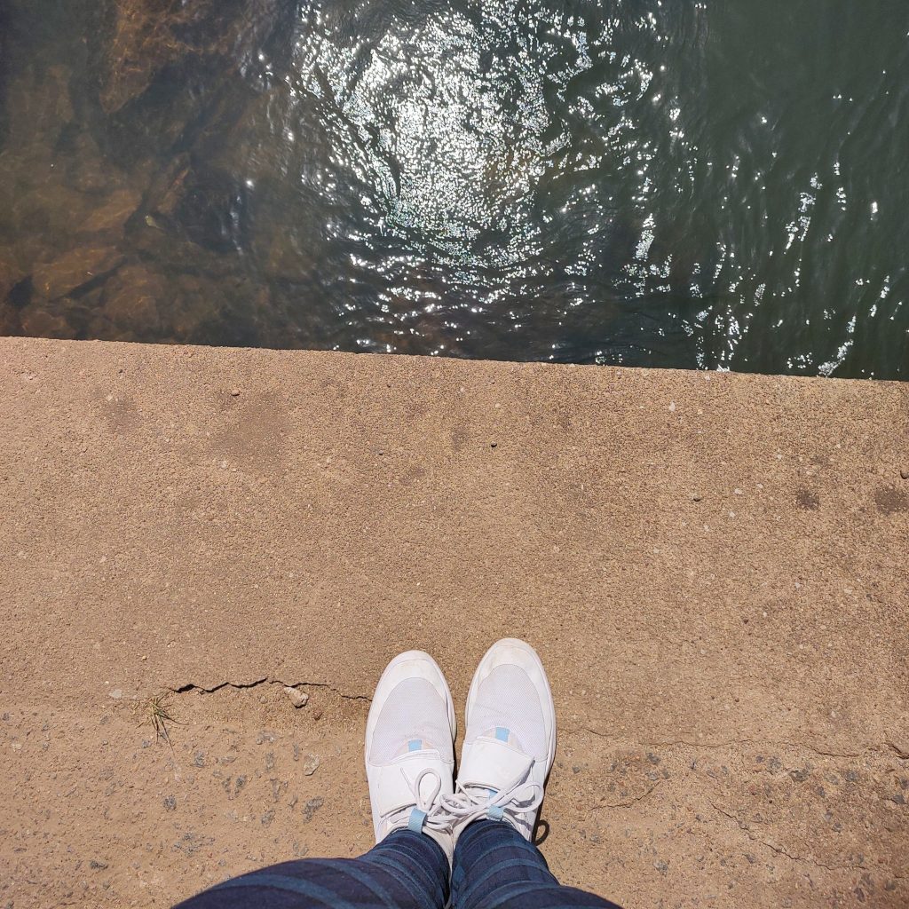 Girl wearing puma shoe near stream